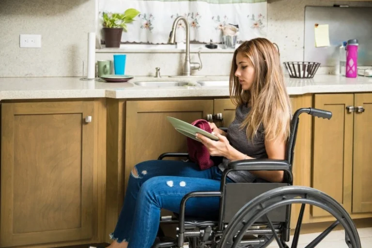 Girl in wheelchair doing dishes in home